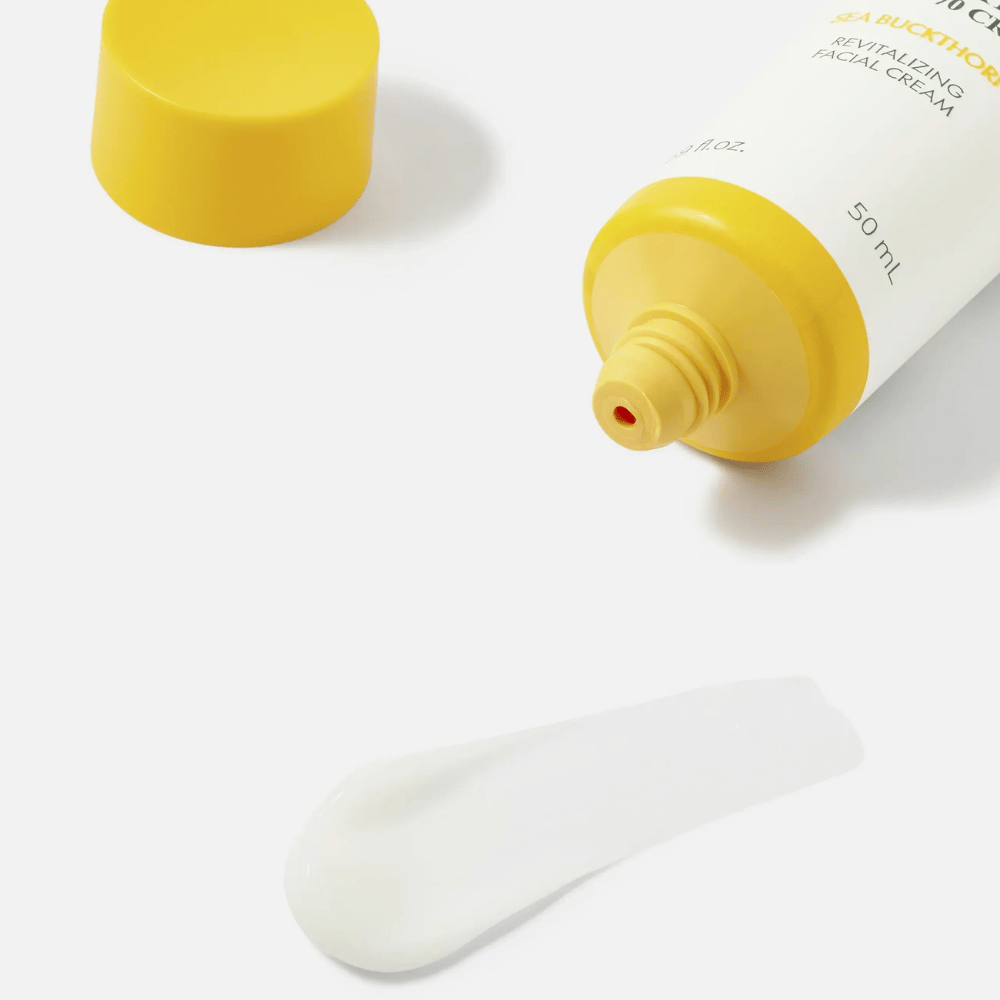 1. Purito SEOUL Sea Buckthorn Vital 70 Cream – Nahaufnahme der leichten weißen Konsistenz der Gesichtscreme neben einer offenen Tube mit gelbem Verschluss
