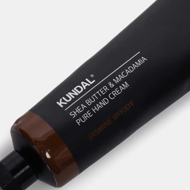 Nahaufnahme von KUNDAL Shea Butter & Macadamia Pure Hand Cream Jasmine Woody, die die stilvolle Verpackung und das Premiumgefühl der Handcreme zeigt.