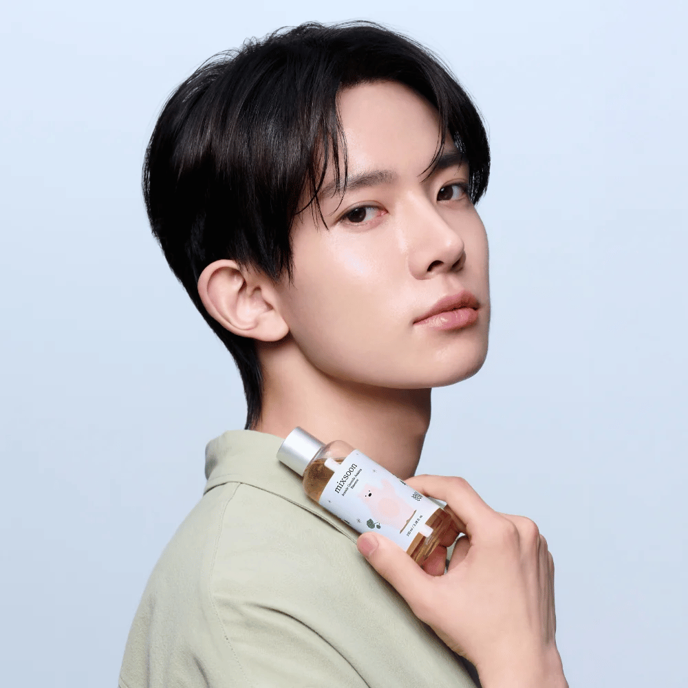 Modell hält Mixsoon Soondy Centella Asiatica Essence in der Hand, zeigt das Produkt für empfindliche Haut.