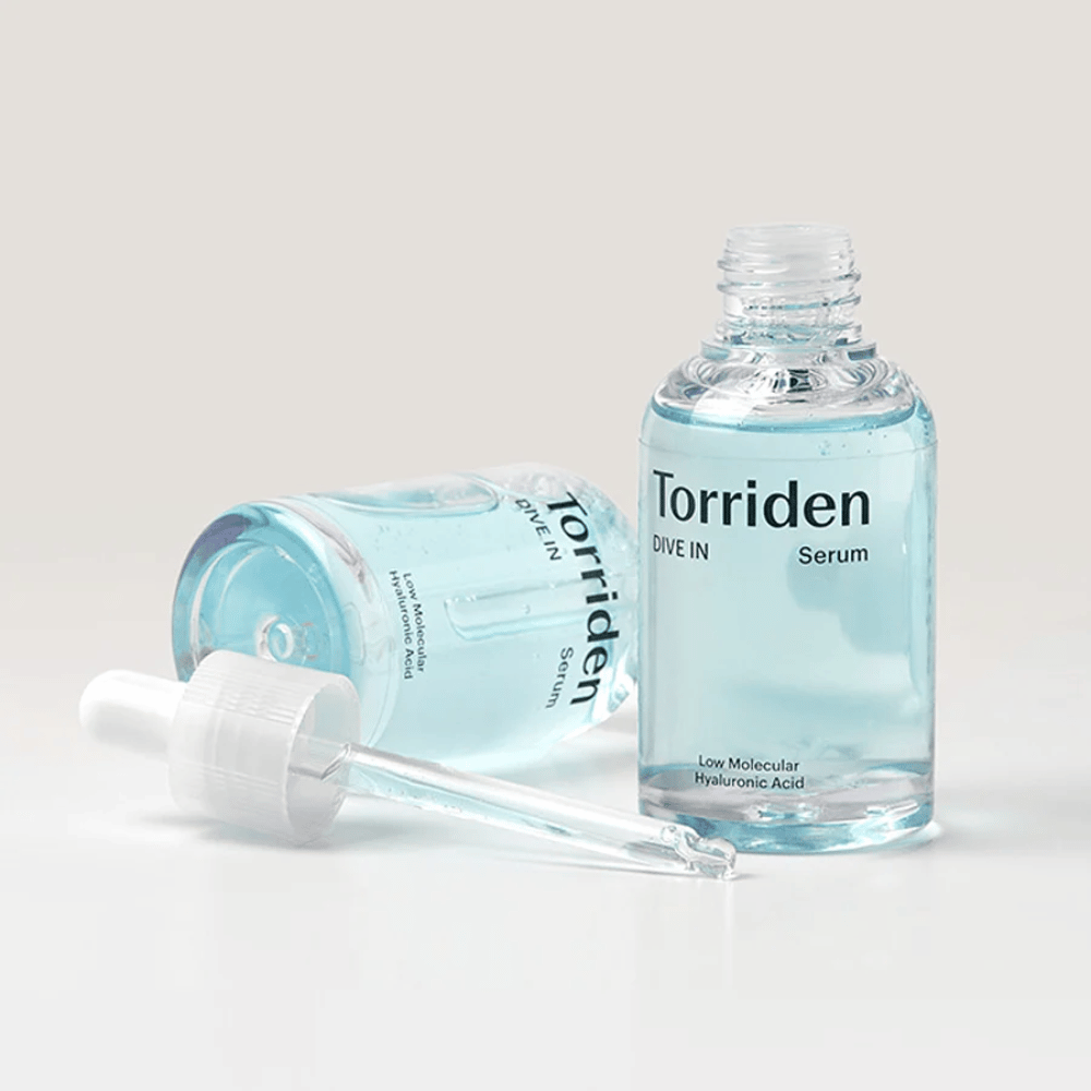 Eine Flasche Torridens DIVE-IN Low Molecule Hyaluronic Acid Serum 50ml neben einer Wasserflasche, die Hyaluronsäureserum und Befeuchtung betont.