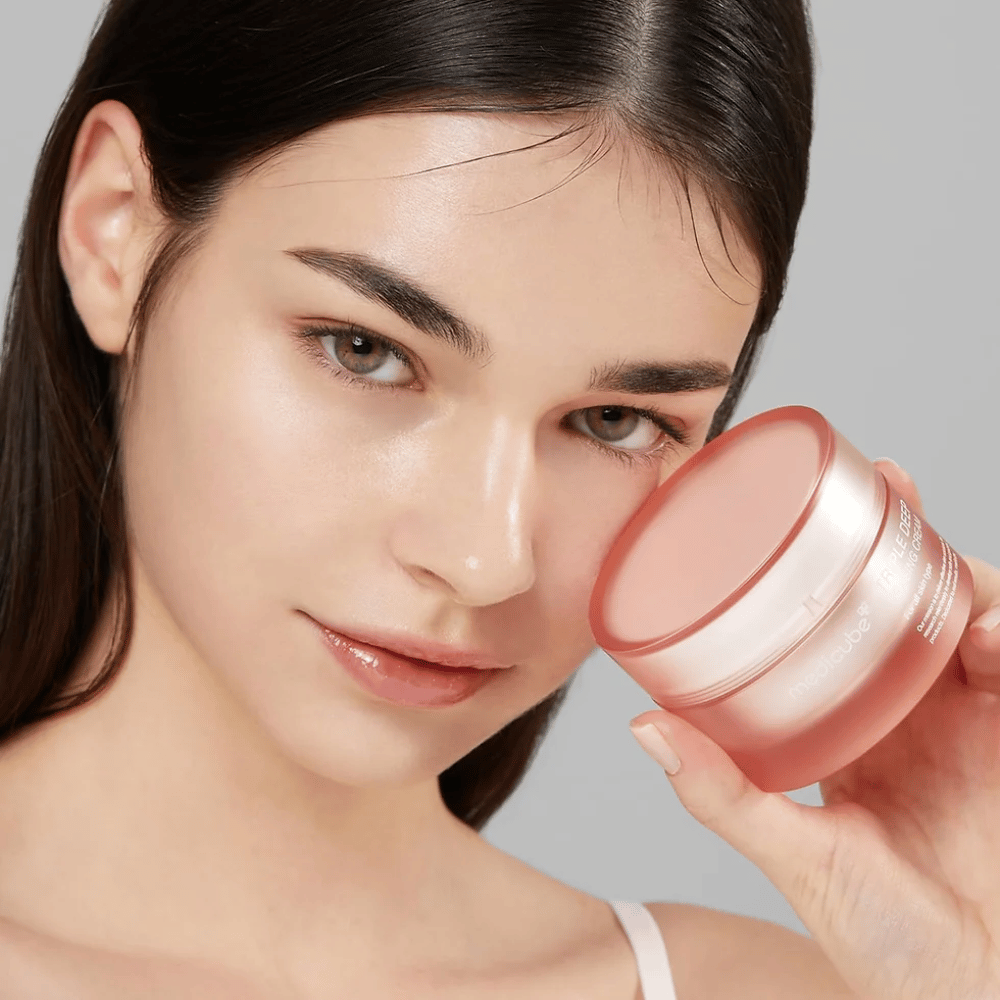 Das Bild zeigt eine Frau, die ein Glas mit Triple Collagen Cream hält. Die Creme ist dafür ausgelegt, die Elastizität und Feuchtigkeit der Haut zu verbessern. Die Haut der Frau sieht glatt und gepflegt aus.




