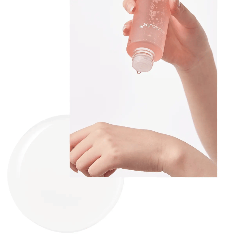 Hand, die Medicube Triple Collagen Toner 4.0 aus einer rosa Flasche auf die Haut aufträgt, zeigt die feuchtigkeitsspendende Konsistenz.