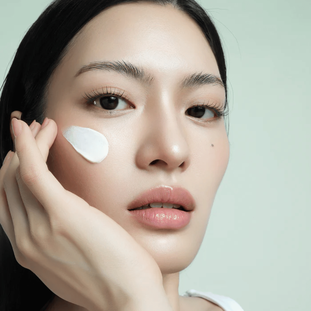 Modell trägt d’Alba Waterfull Mild Sun Cream SPF 50+ im Gesicht auf. Leichter, feuchtigkeitsspendender Sonnenschutz mit Mineralfilter, perfekt für den täglichen Gebrauch und empfindliche Haut.