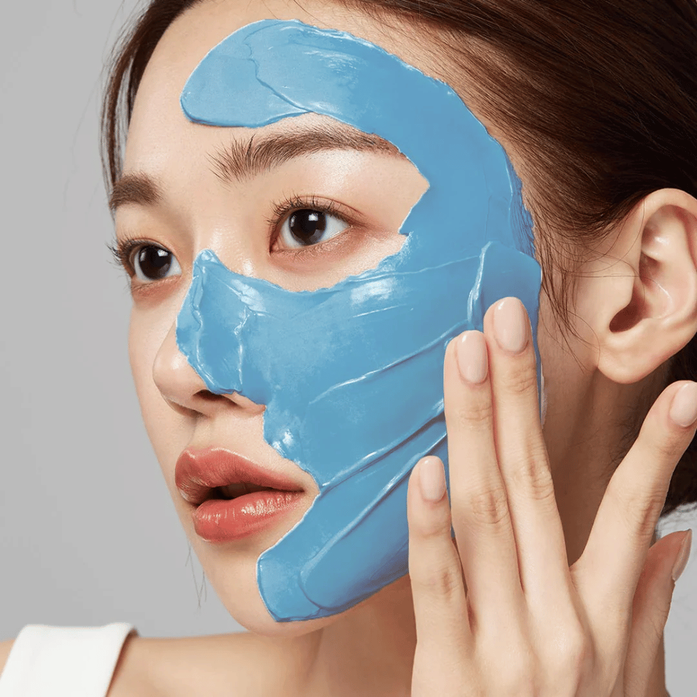 Modell mit blauer Gesichtsmaske von Medicube, deckt die T-Zone für Porenpflege ab.