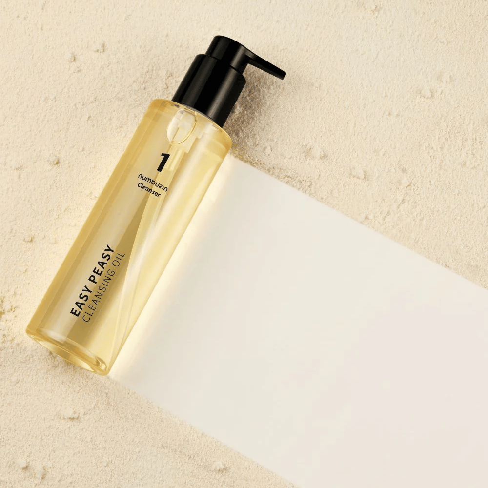 Numbuzin No.1 Easy Peasy Cleansing Oil liegend auf sandfarbener Fläche mit Schatten.