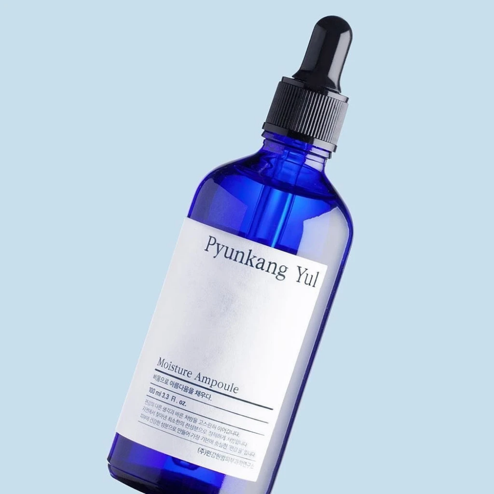 Eine blaue Flasche auf blauem Hintergrund mit Pyunkang Yul's Moisture Ampoule 100ml Serum.